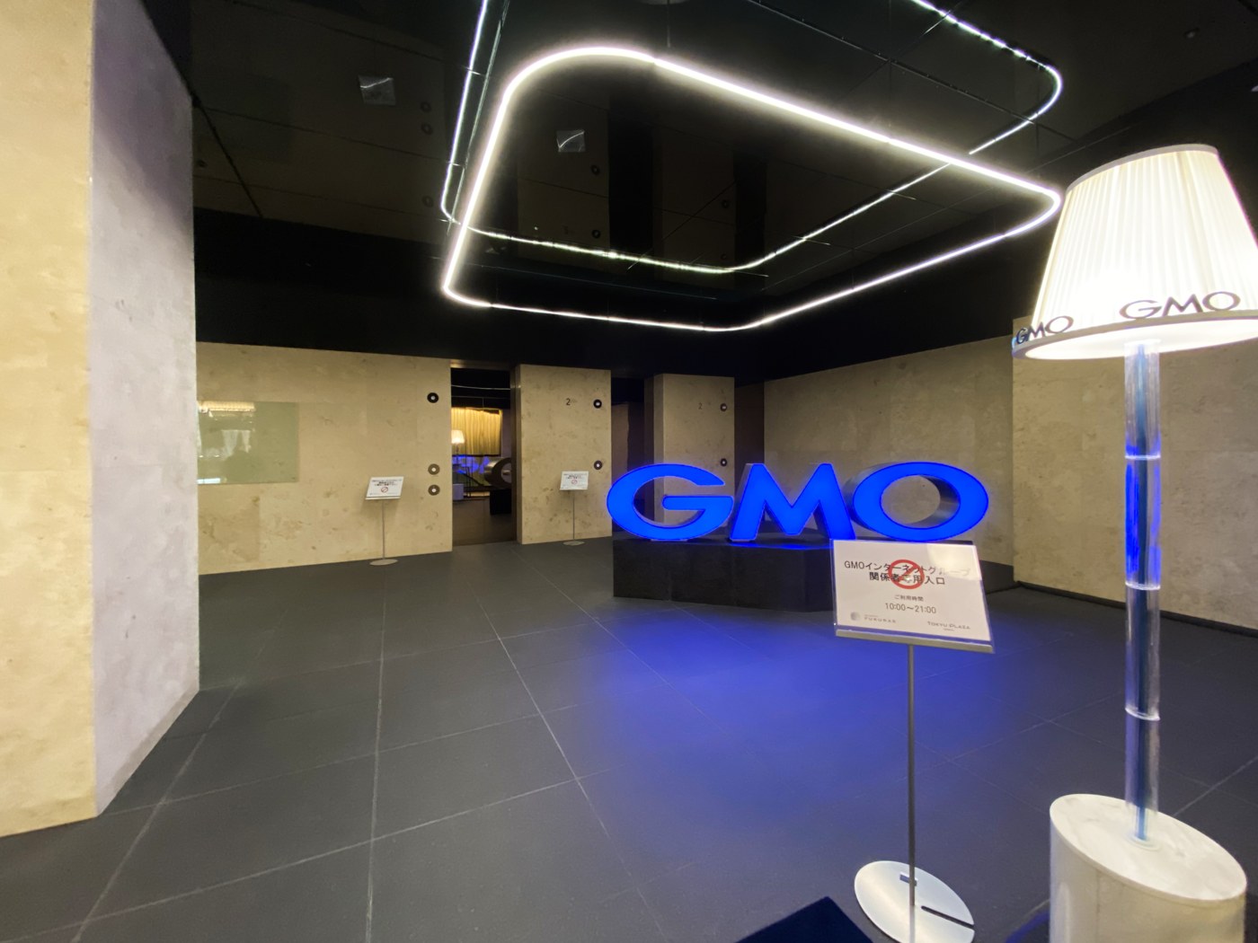 Ingresso degli uffici GMO nello Shibuya Fukuras a Tokyo, con il logo blu del gruppo.