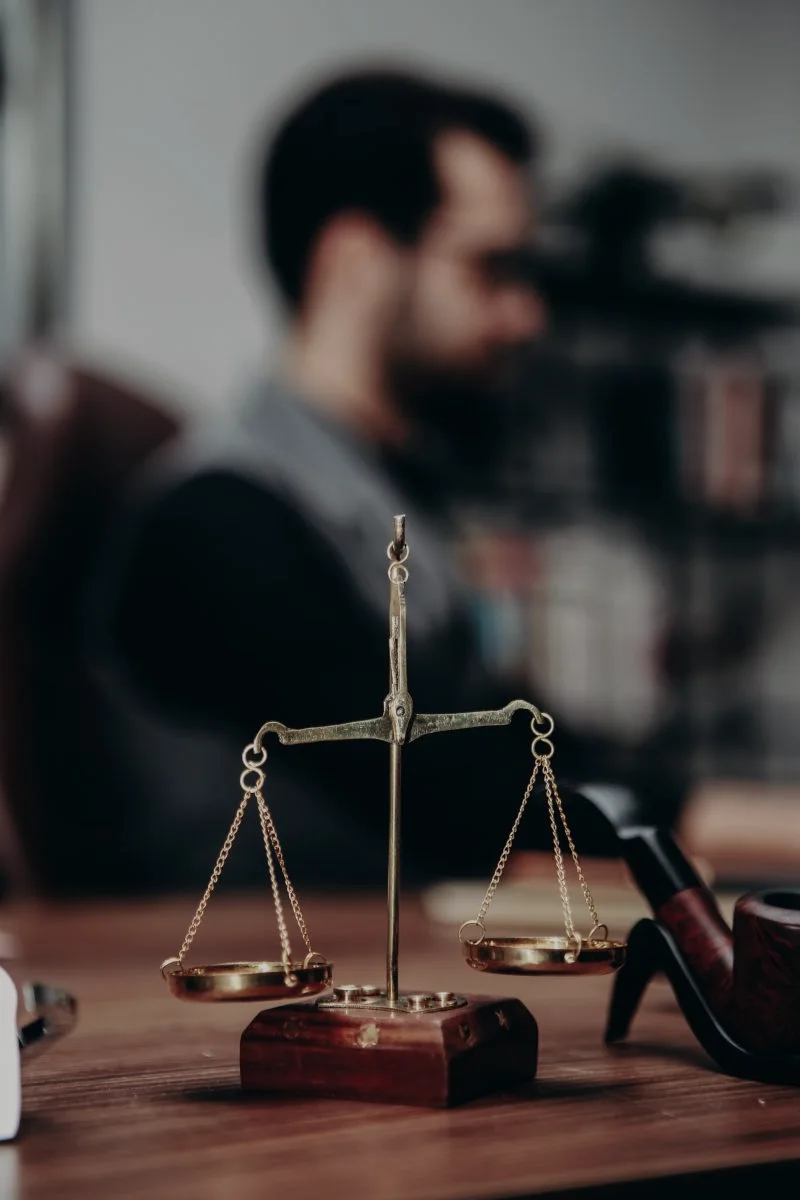 Documenti e bilancia su un tavolo di lavoro legale; scena illustrativa.