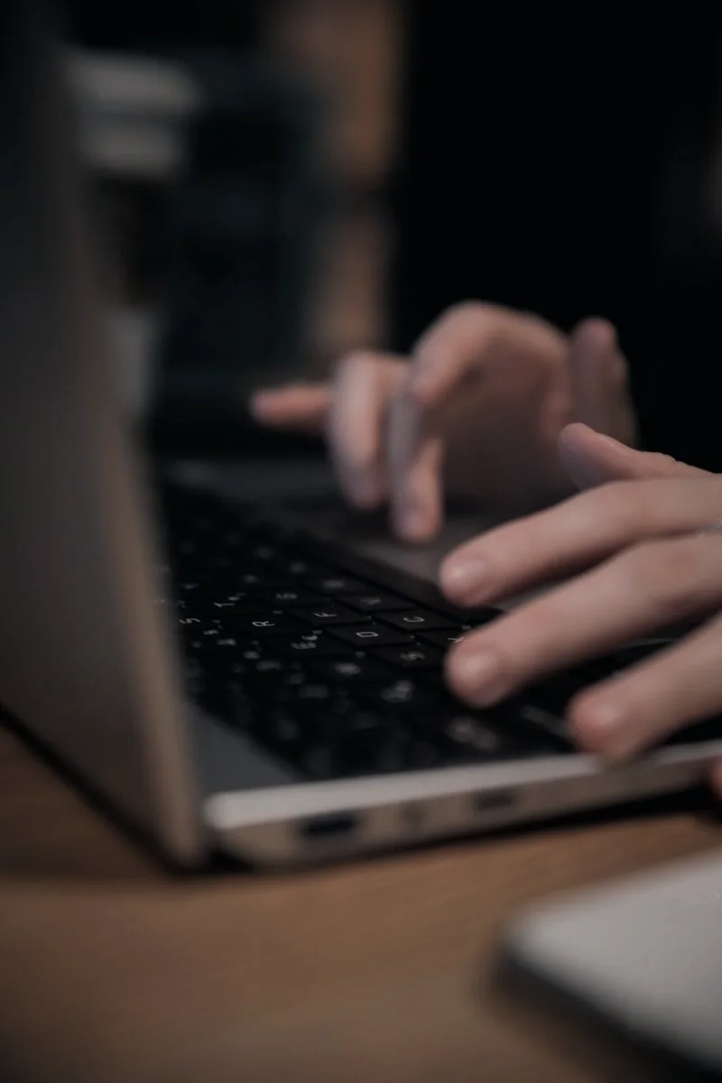 Dettaglio di mani al computer durante un’attività professionale.